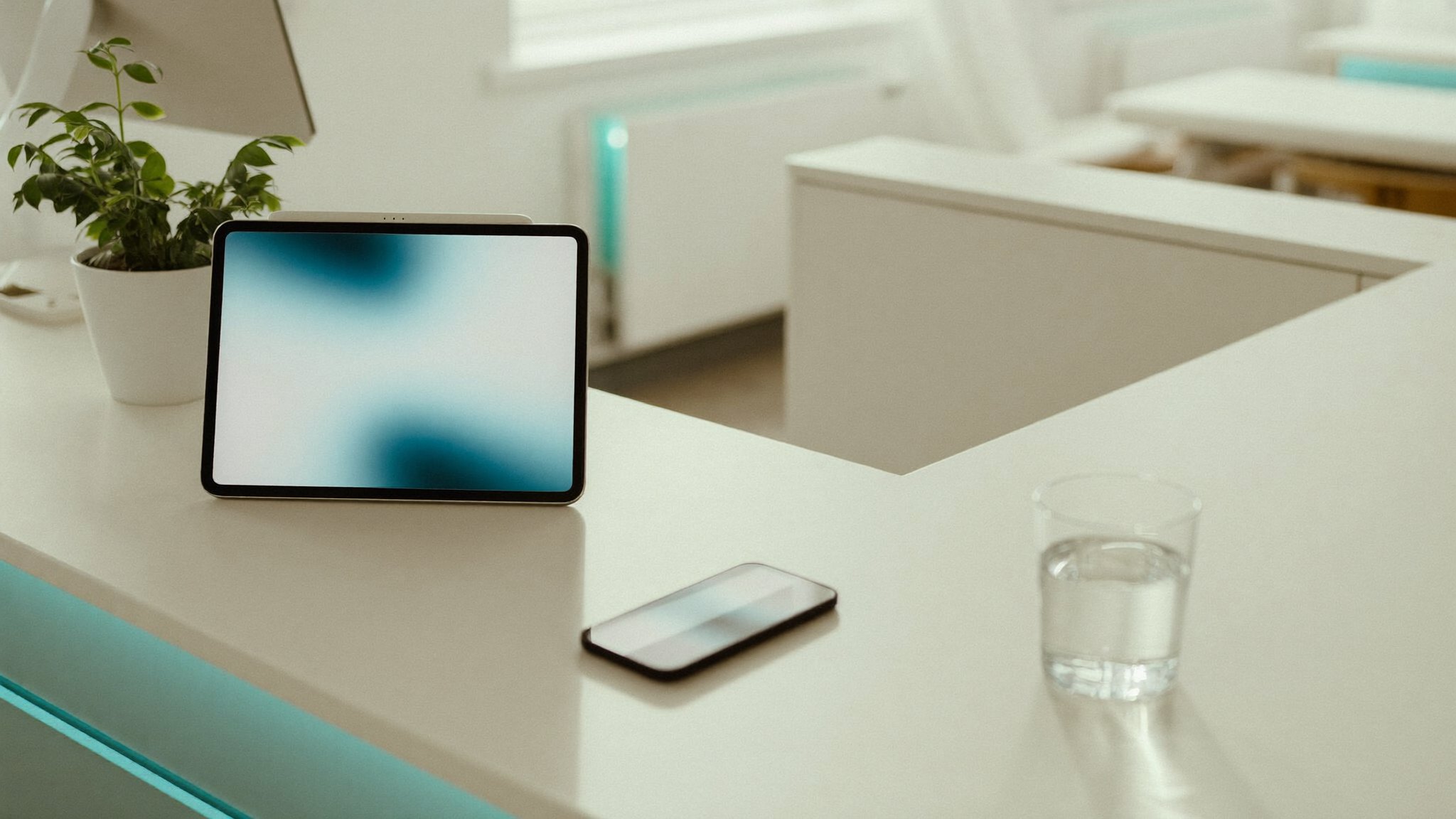 Smartphone sobre a mesa de uma recepção de clínica moderna e clara, com tons de ciano